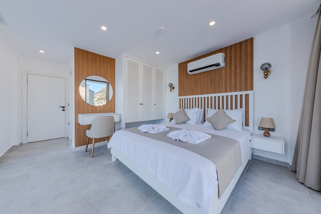 A bedroom with white walls and wooden floors